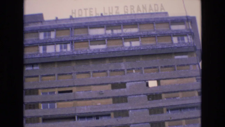 1972 Spain home-movie frame showing the HOTEL LUZ GRANADA sign near the top edge and multiple rows of windows across the concrete exterior.