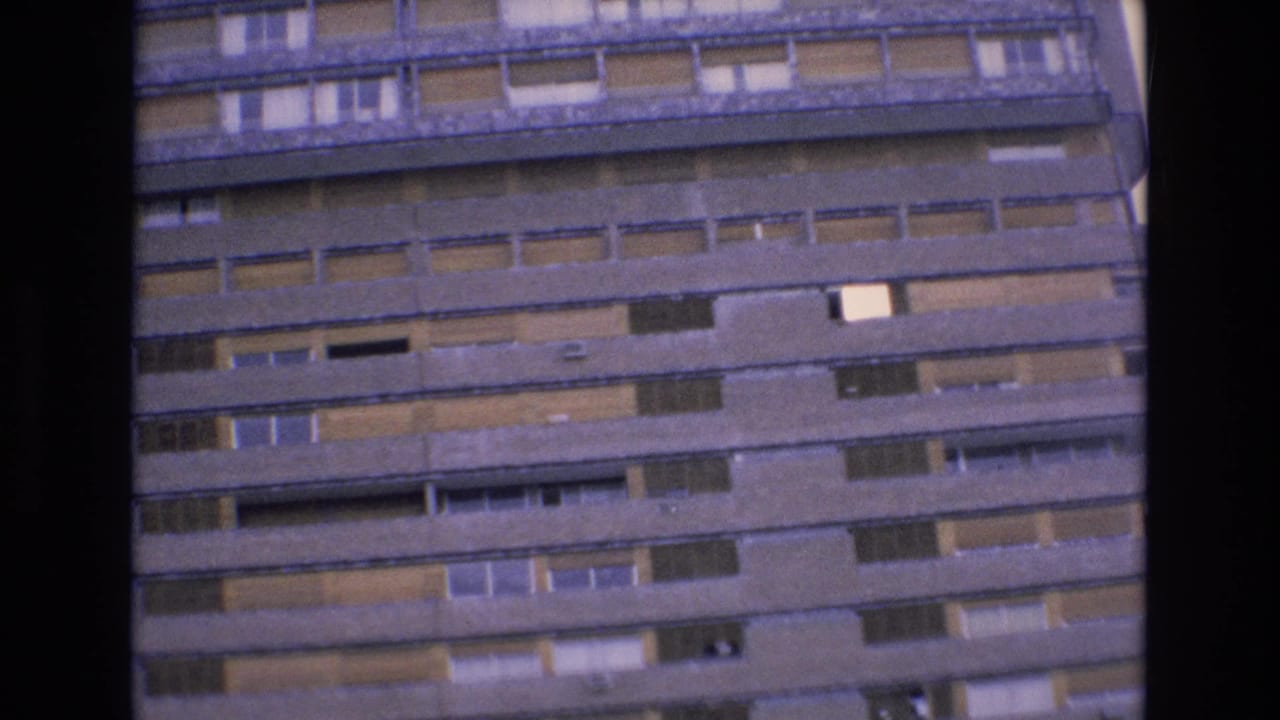 Multi-story hotel facade with horizontal balcony lines and many windows.