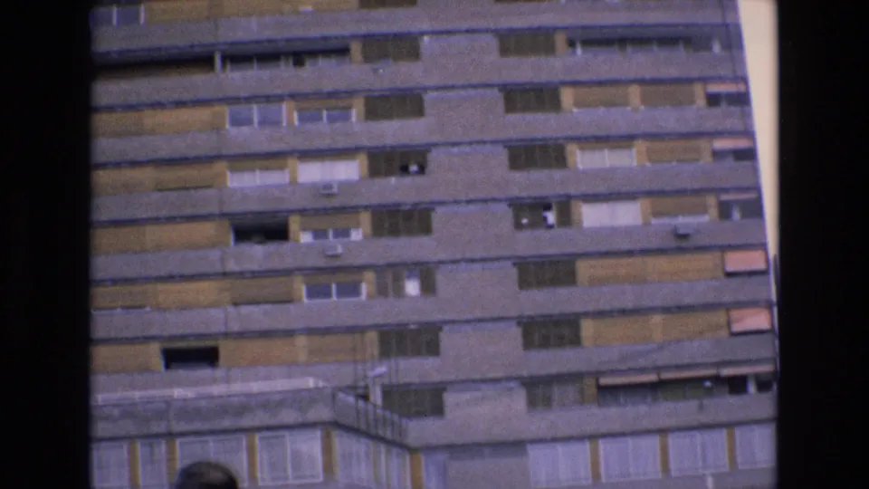 Granada travel footage frame from 1972 showing the upper portion of a large concrete building with balcony bands and window shutters.
