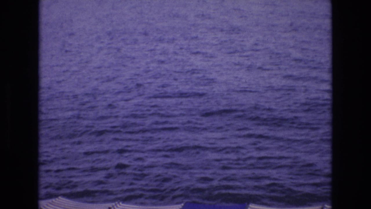 Open ocean with a few beach umbrella tops visible along the lower edge.