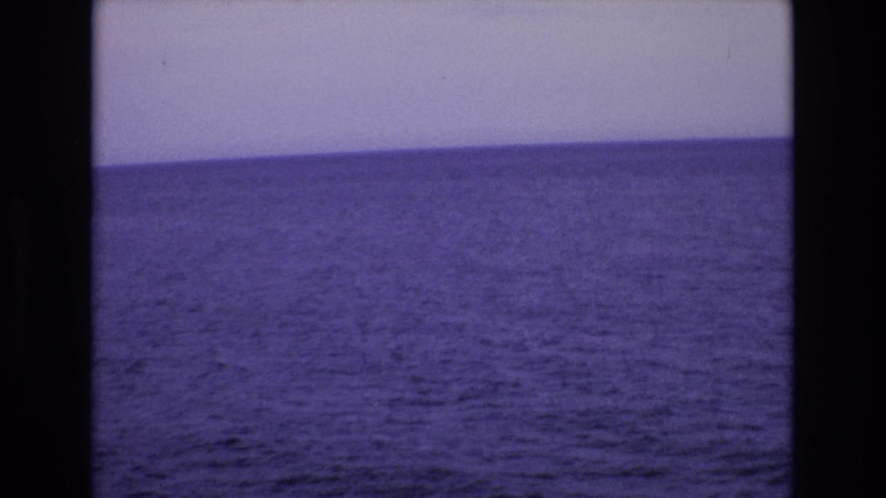 Wide ocean horizon with pale sky and visible 8mm frame edges.