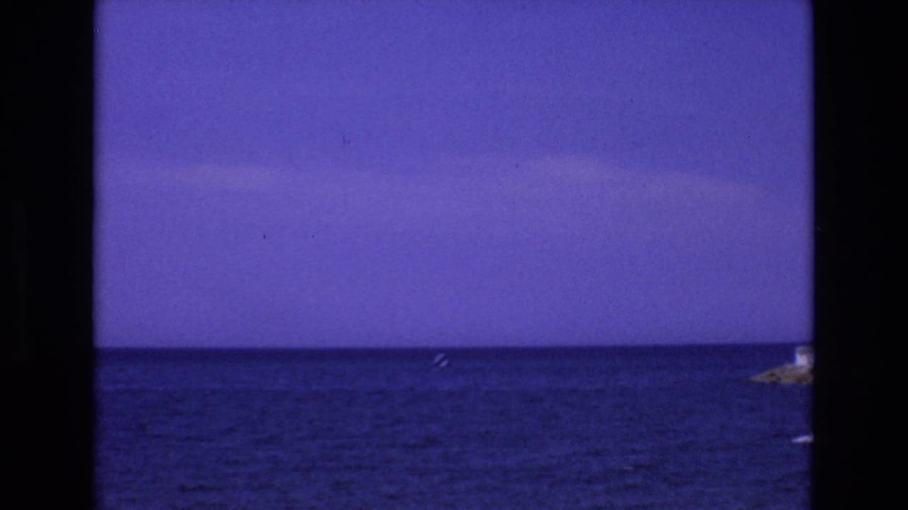 Blue sea and horizon under a clear sky with a small distant boat.