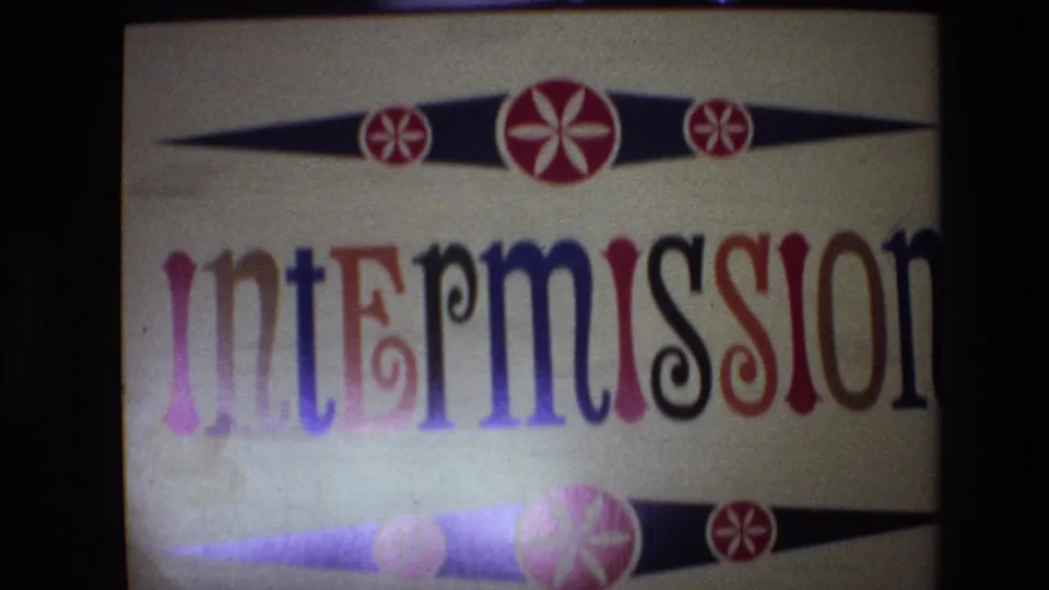 1972 Spain 8mm frame of the intermission card, with the word partly cropped to the right and starburst ornaments above and below.