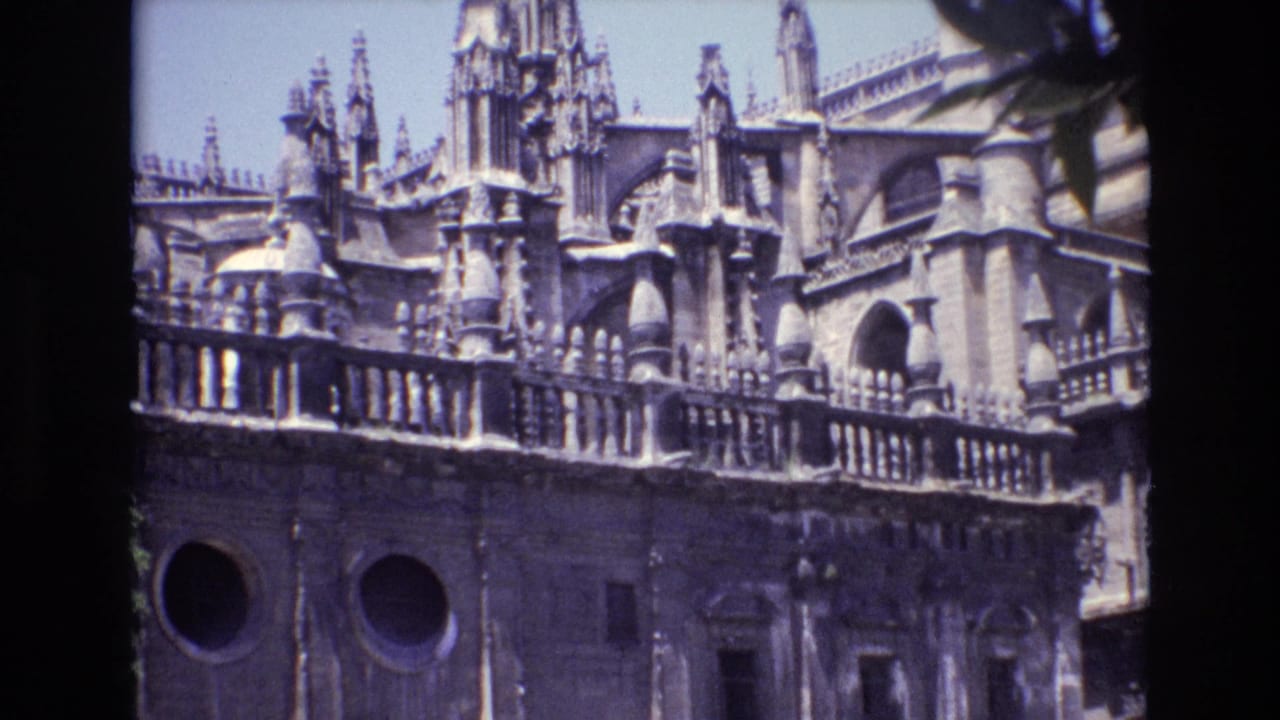1972 Spain 8mm frame showing an ornate cathedral facade with pointed spires, stone balustrade, circular windows, and projected-film borders.