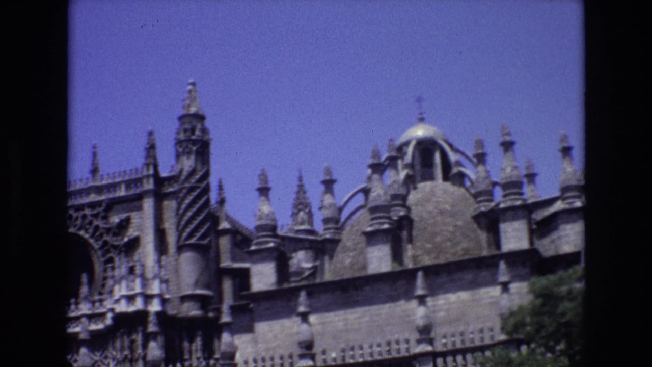 Closer view of church spires, carved stonework, and a dome along the roofline.