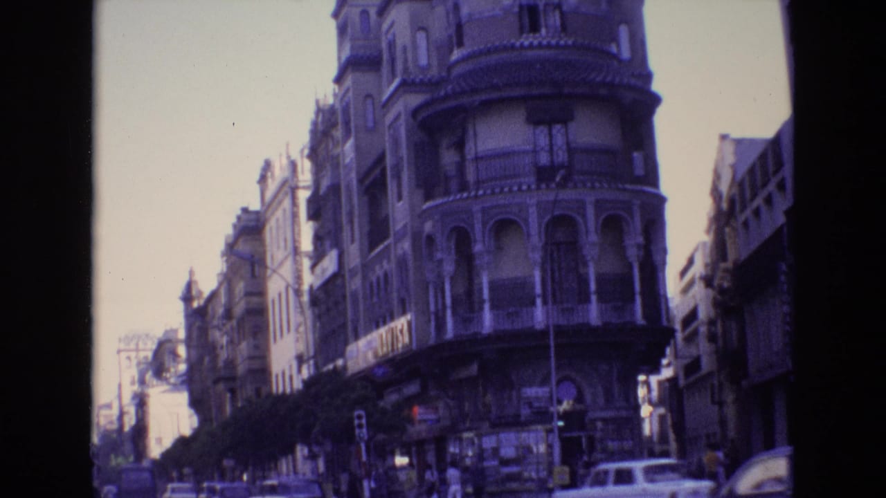 Historic street facade with traffic passing below balconies.