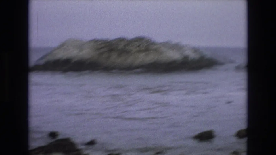 The final 8mm frame shows the same California coastal rock softened by motion blur or focus shift, with gray-blue water and dark foreground stones below.