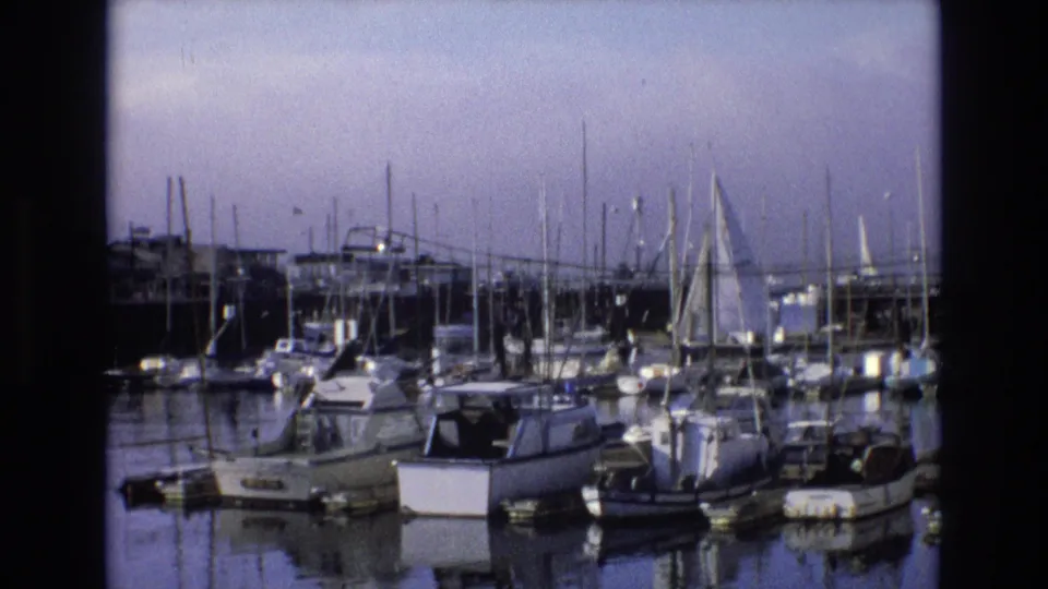 1973 Central Coast California marina view with pleasure boats, sailboat masts, docks, and soft 8mm color fading.