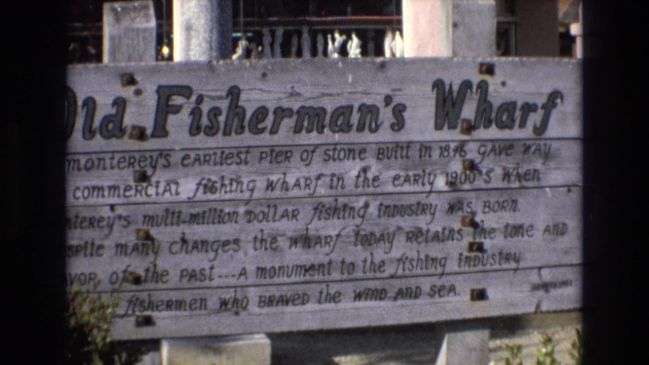 Weathered wooden Old Fisherman's Wharf sign with handwritten history text.