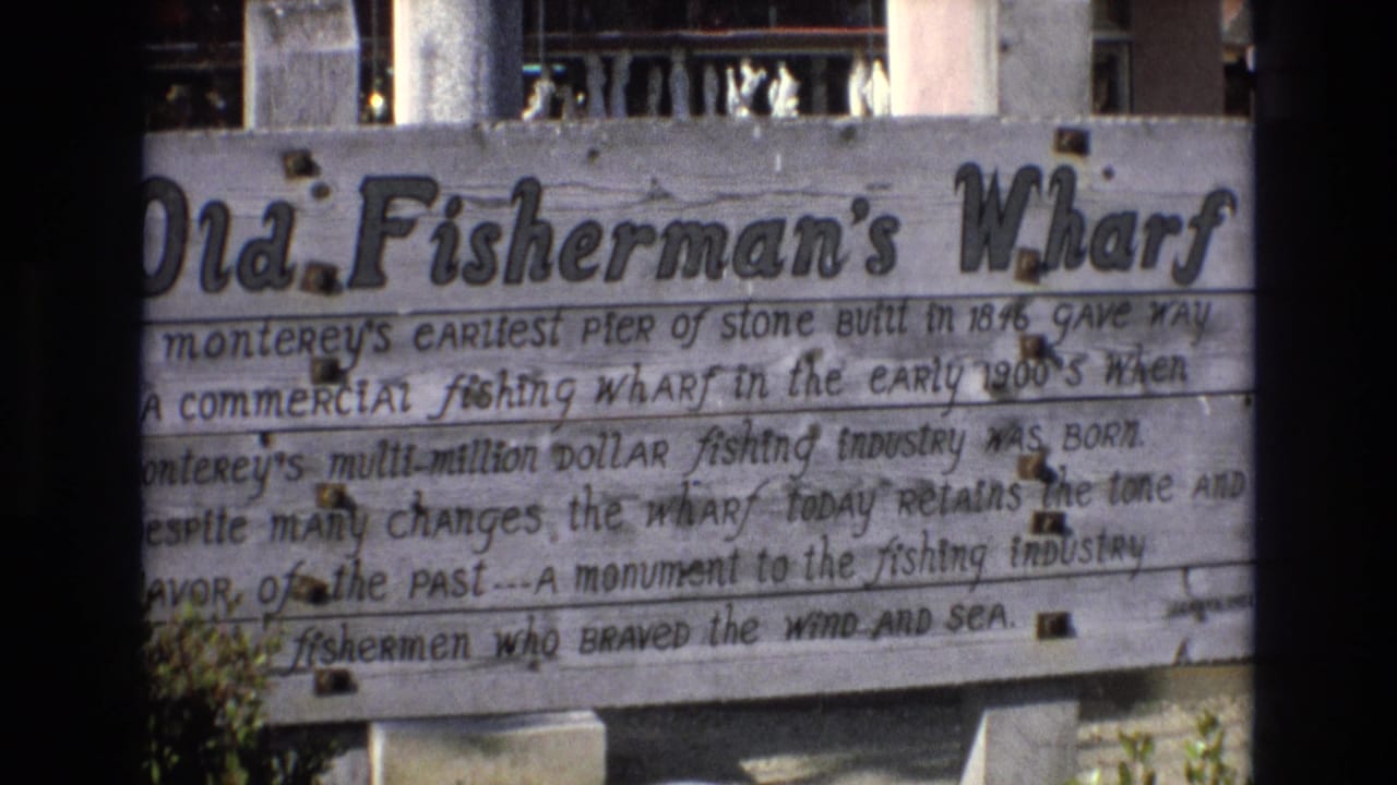 Weathered wooden Old Fisherman's Wharf sign with painted historical text.