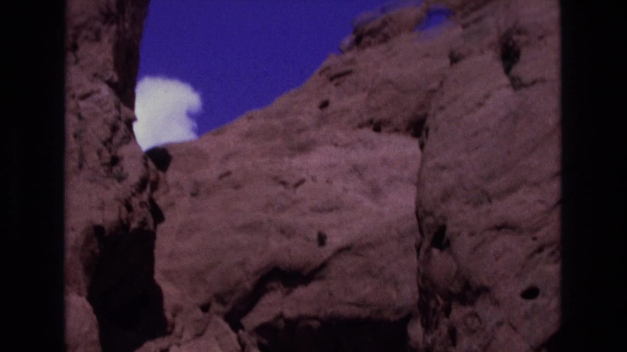 Sandstone cliffs with a white cloud visible above a rock opening.