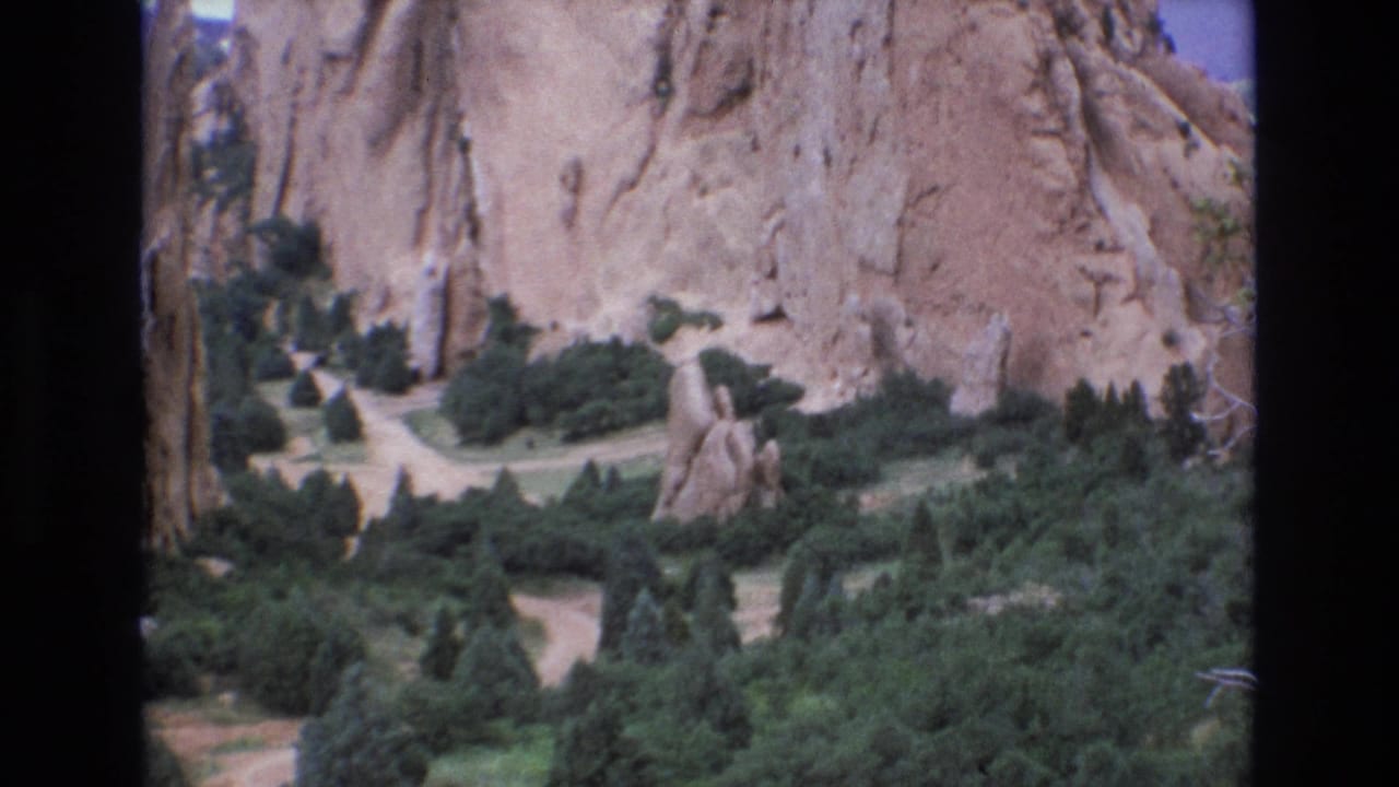 Rock spire and paths below tall sandstone formations.