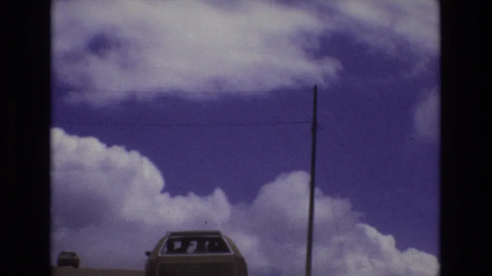 A smaller distant car and the station wagon sit below the horizon line in this 1973 Colorado highway view, with clouds and a utility pole filling most of the frame.
