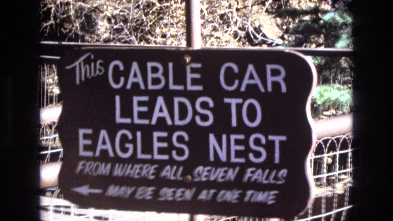 Hand-painted sign directing visitors to a cable car to Eagles Nest.