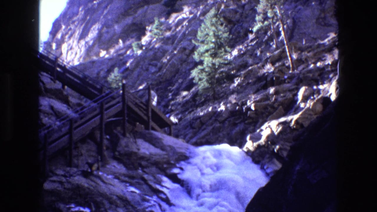 Wooden stairs climb beside a rocky canyon with white water below.