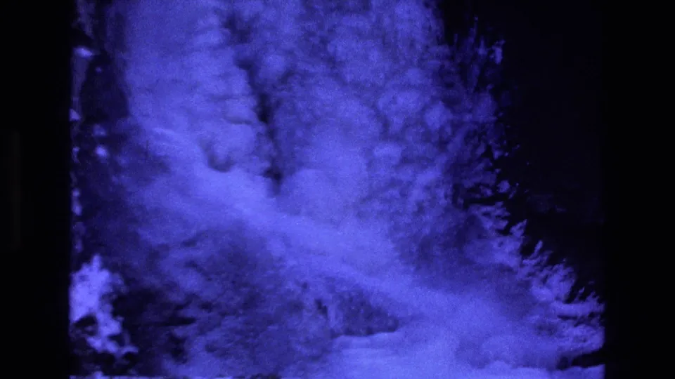1973 Colorado 8mm frame with a closer view of the frozen waterfall base, showing heavy blue ice, snow texture, and shadowed rock.