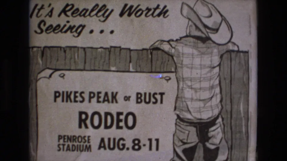 1973 Colorado Springs 8mm frame showing a hand-drawn Pikes Peak or Bust Rodeo poster for Penrose Stadium with a cowboy leaning on a fence.