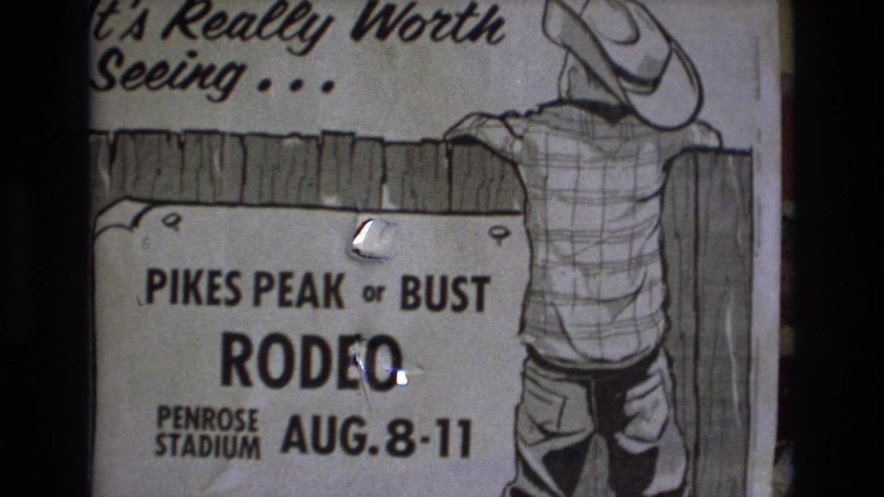 1973 Colorado Springs 8mm frame showing a hand-drawn Pikes Peak or Bust Rodeo poster for Penrose Stadium with a cowboy figure leaning over a wooden fence.