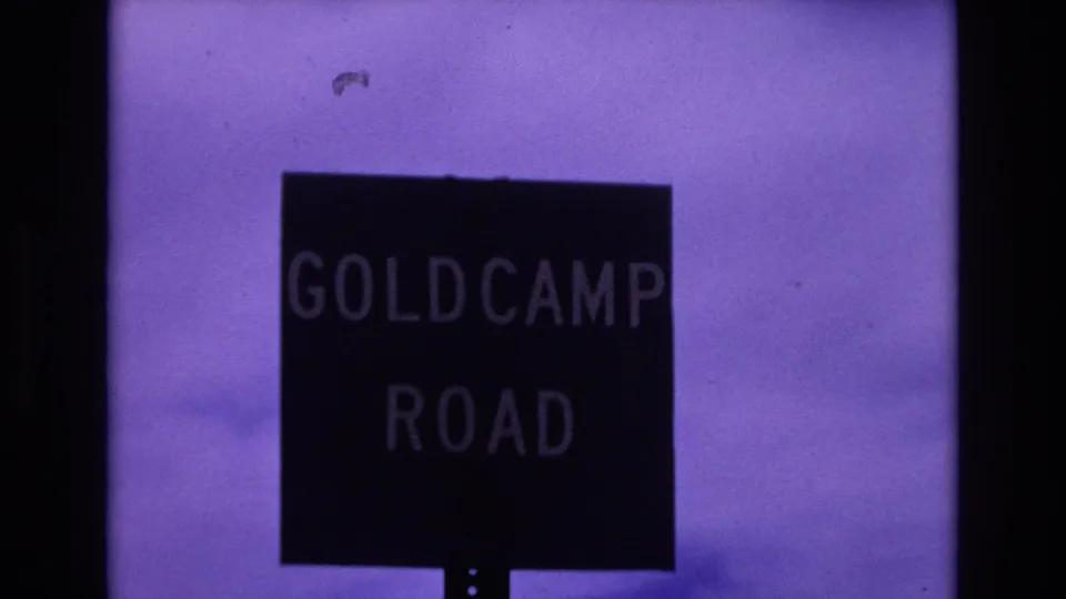 1973 Colorado Springs frame showing a closer roadside view of the Goldcamp Road sign with grain and small film marks visible.