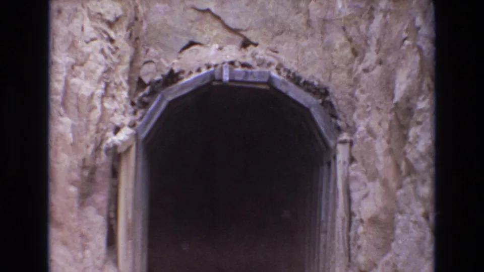 1973 Colorado Springs home-movie frame with the camera closer to the dark arched tunnel mouth and its rough rock surround.