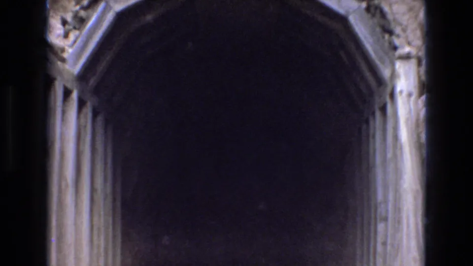 Tight 1973 Colorado Springs 8mm view into the dark arched tunnel entrance, with the wooden frame and rough rock mostly cropped by the zoom.