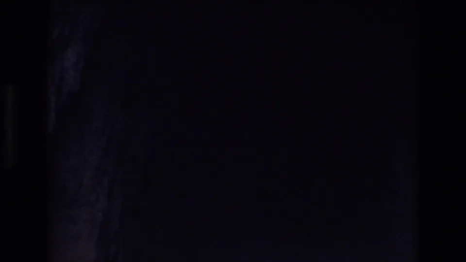 1973 Colorado Springs 8mm frame showing the cave view dropping into near darkness, with only faint rock texture visible along one side.