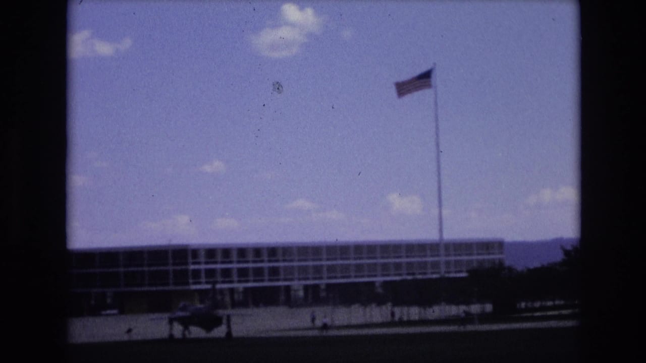 American flag flying above a modernist building on a base exterior.