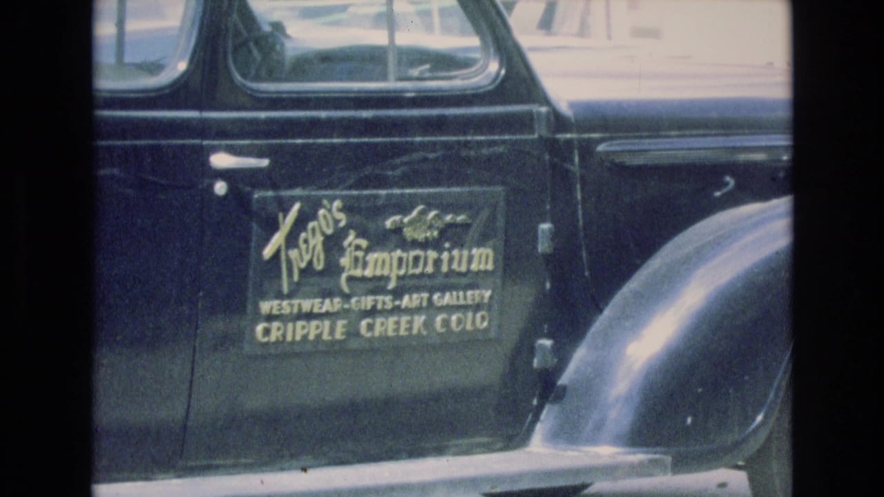 Close view of a black vintage car door with Trego's Emporium lettering.