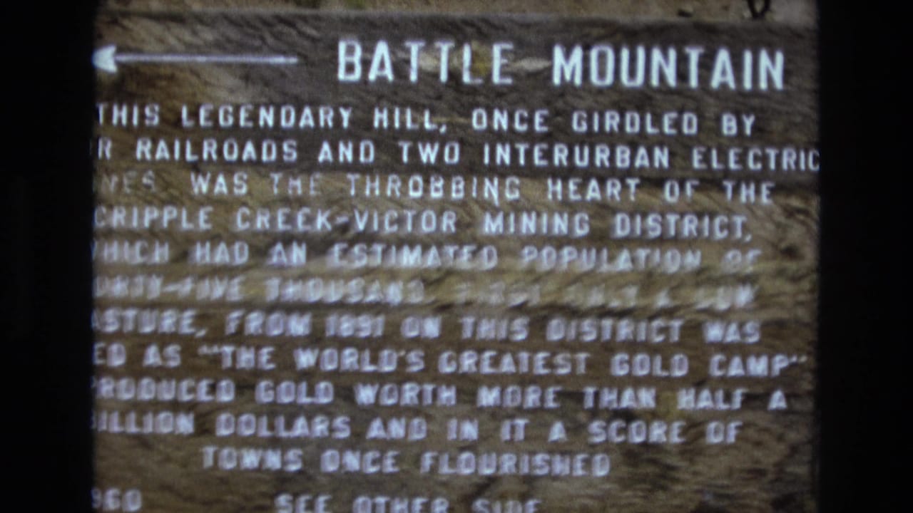 Battle Mountain sign fills the frame with partially readable historical text.