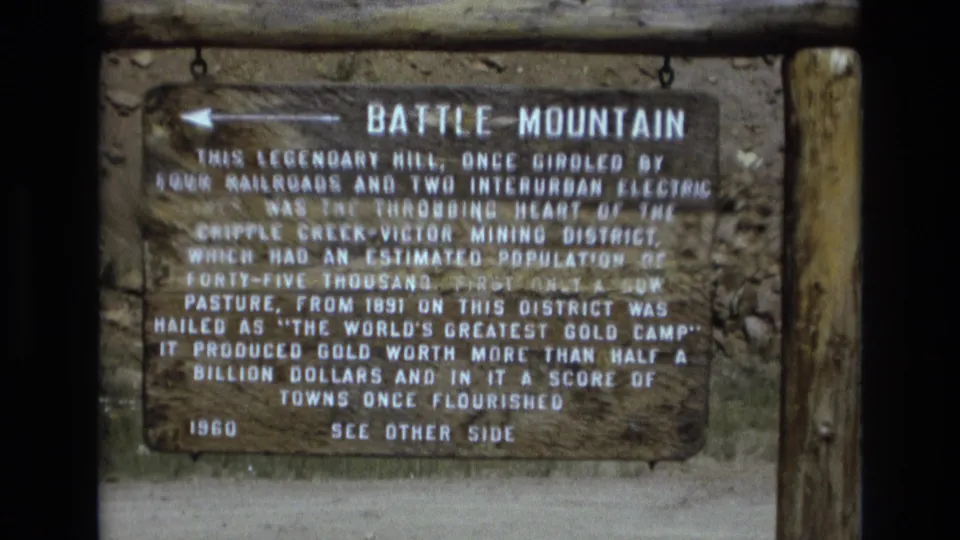 Wider 1973 Colorado view of the Battle Mountain historical marker mounted on wooden posts, with the full sign and arrow visible.