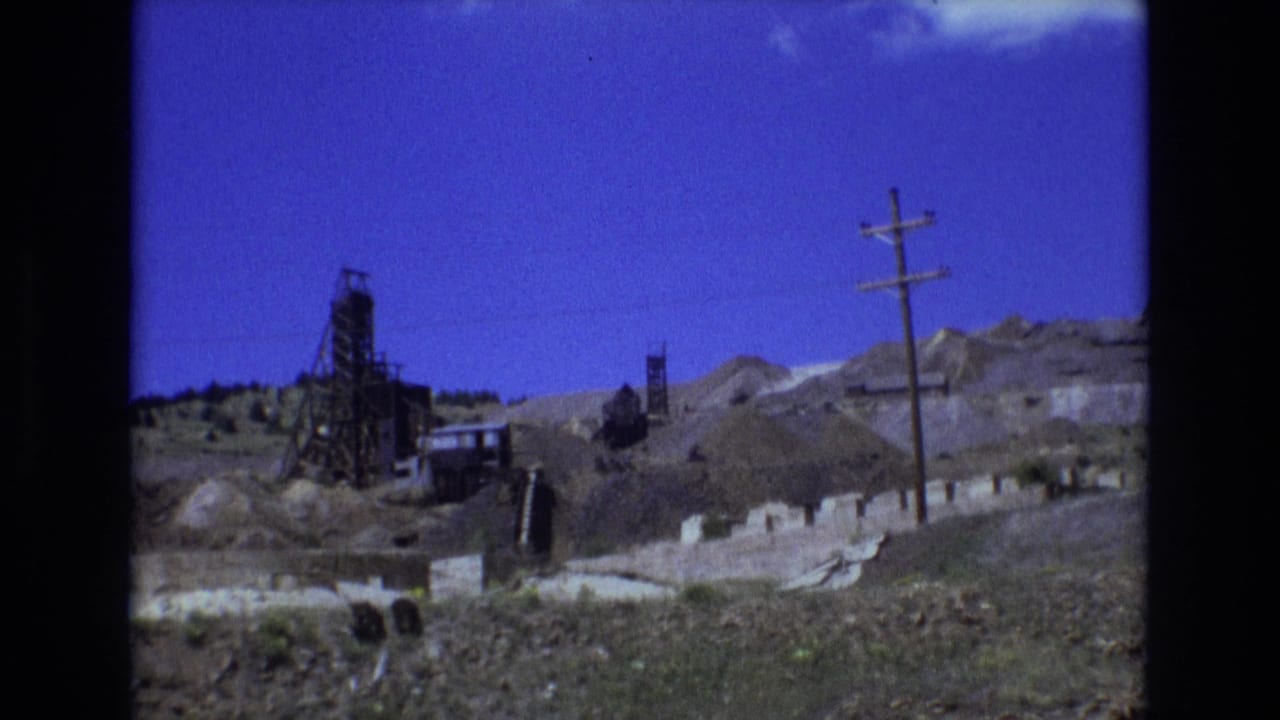 Mining works and utility pole seen across a rocky hillside landscape.