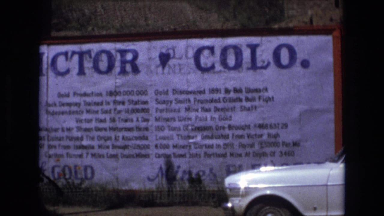 Large Victor, Colo. sign fills the frame with a white car at the lower right.