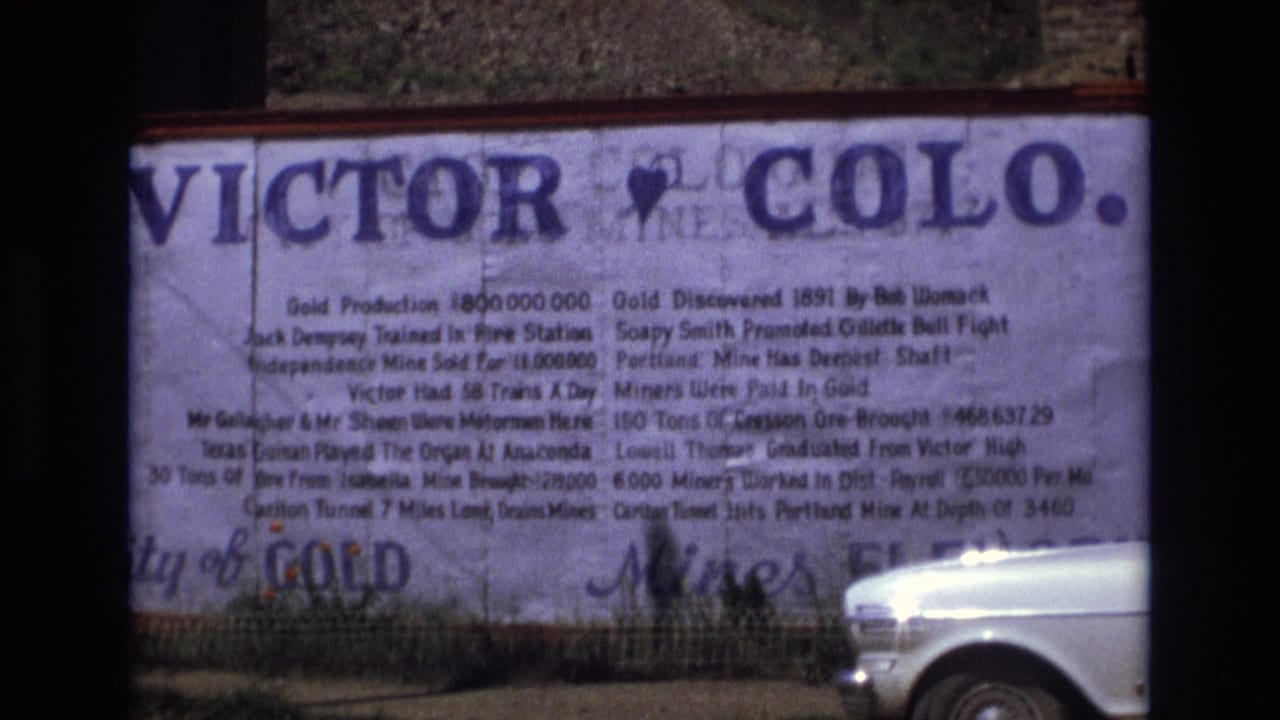Large Victor, Colorado history sign with a white car passing at the lower right.