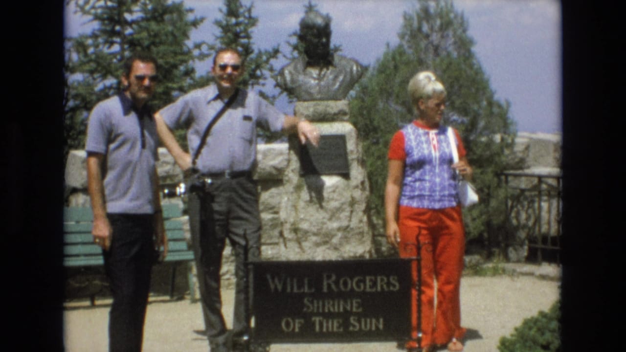 Two men and a woman stand near the Shrine of the Sun marker in bright sunlight.