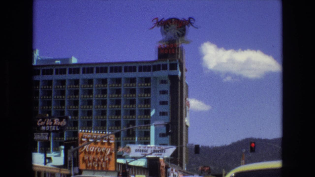 Harvey's Resort Hotel tower and neon rooftop sign seen beside motel signage and traffic lights.