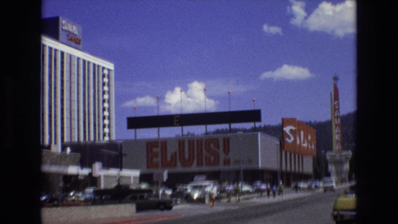 1973 Lake Tahoe, Nevada 8mm frame showing the Sahara hotel exterior with a large ELVIS! facade sign, period cars, pedestrians, and mountains in the background.