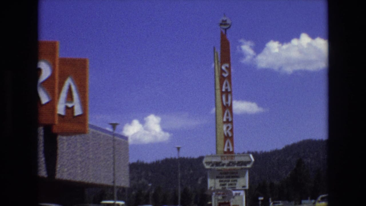 Partial Sahara sign at left and tall vertical Sahara sign above a marquee.