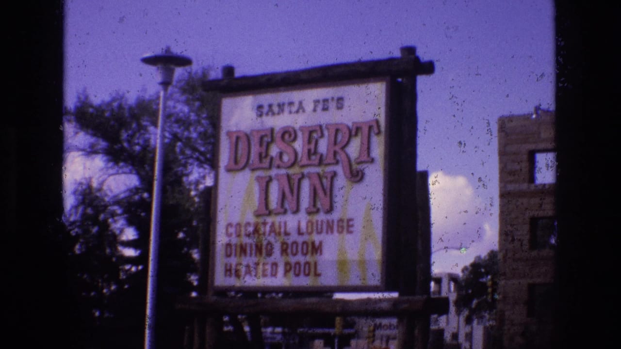Santa Fe's Desert Inn sign beside trees and a partial building.
