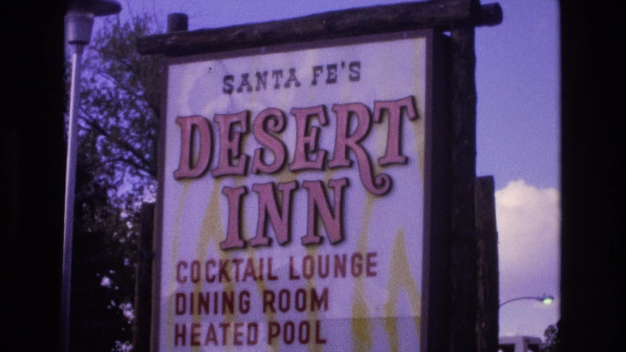 Close 1973 New Mexico 8mm view of the Santa Fe's Desert Inn sign, showing large pink lettering and listings for cocktail lounge, dining room, and heated pool.