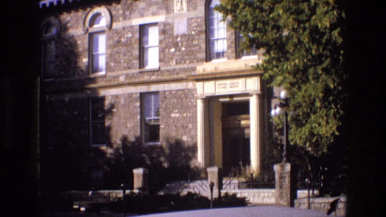 1973 New Mexico 8mm frame showing a stone United States Court House facade with a columned doorway, railings, windows, and partial tree shade.