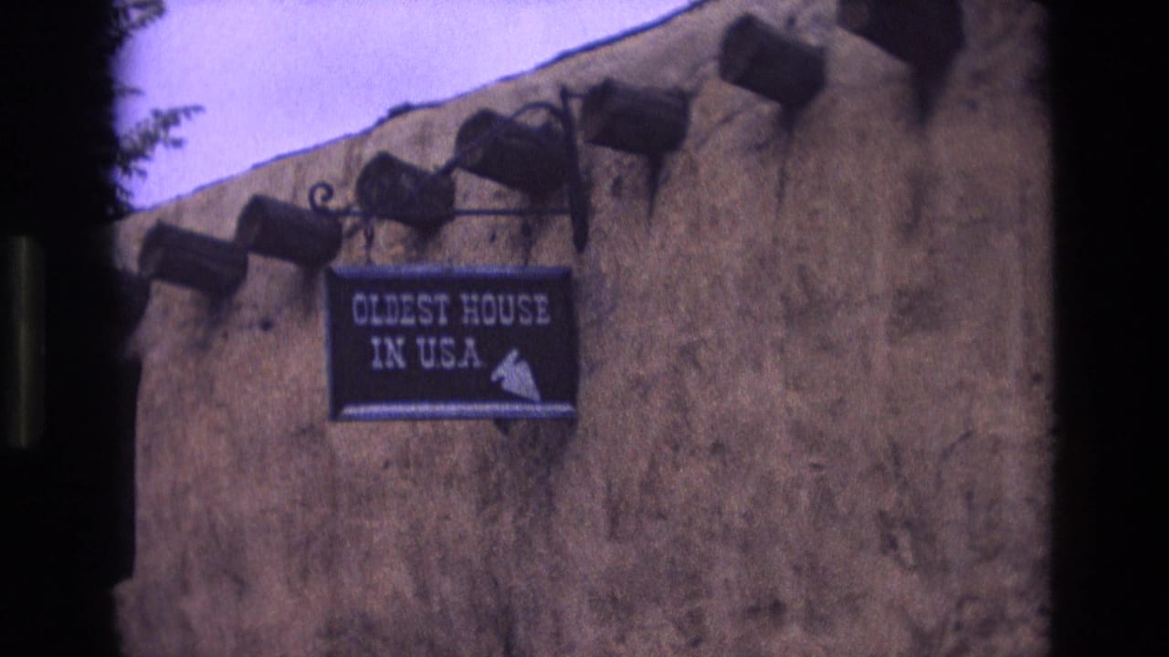 Hanging sign on an adobe wall reading "OLDEST HOUSE IN USA."
