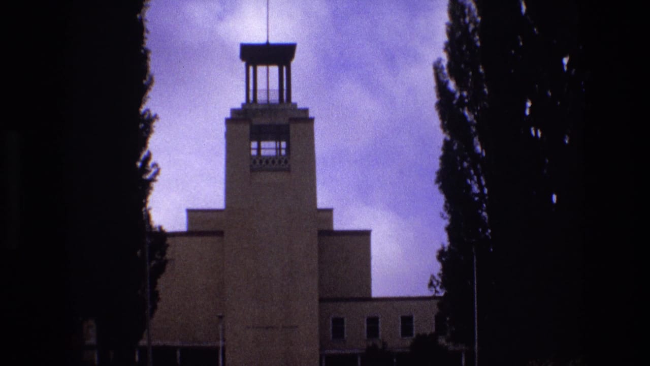 Central building tower and tree silhouettes beneath a cloudy blue-purple sky.