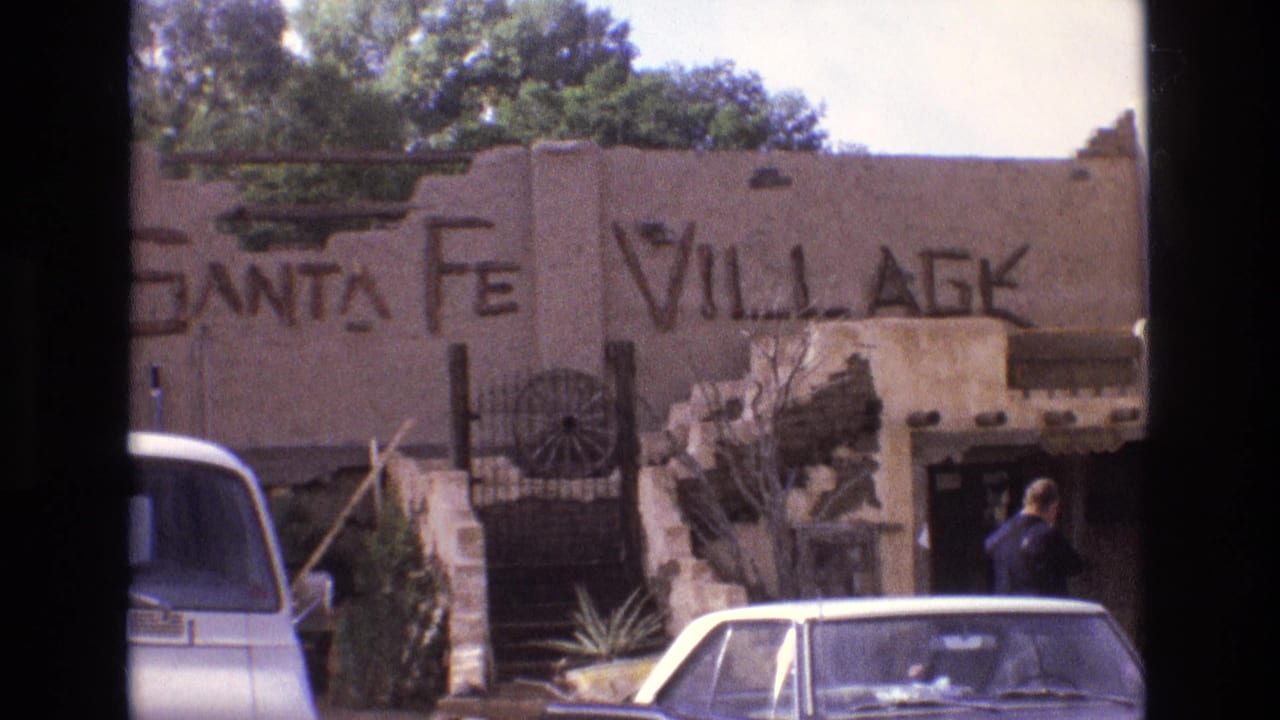 Santa Fe Village facade with parked cars and an adult near the entrance.