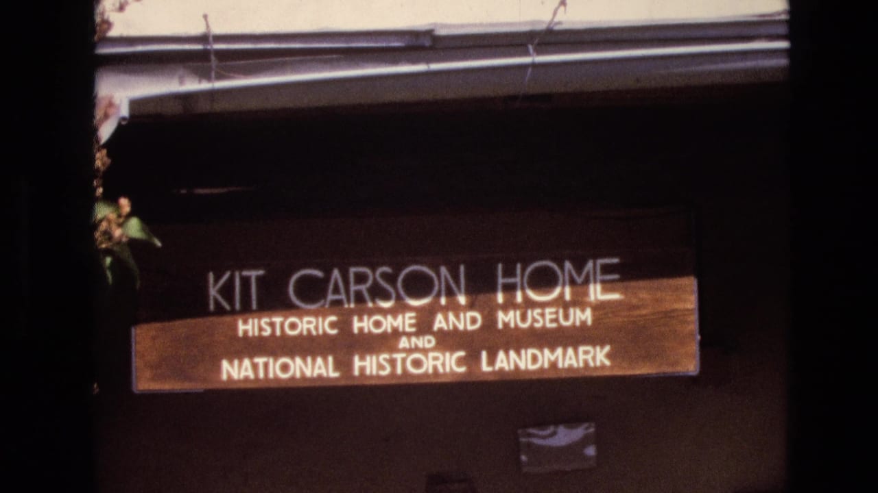 Wooden Kit Carson Home historic home and museum sign on a dark exterior wall.