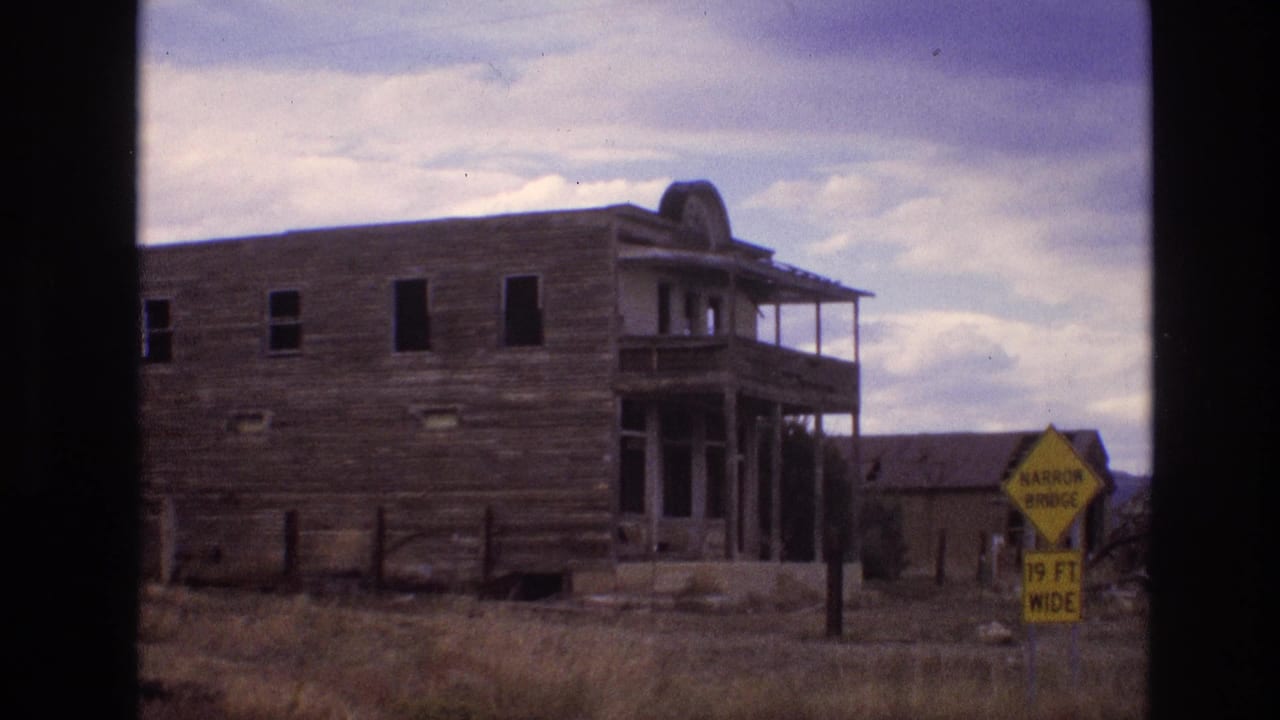 Weathered wooden building with a yellow narrow bridge sign at the right edge.