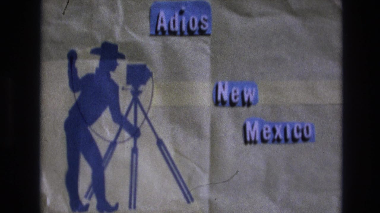 1973 New Mexico 8mm home-movie title card showing a blue cowboy silhouette beside a tripod camera with purple cutout text reading “Adios” and “New Mexico.”