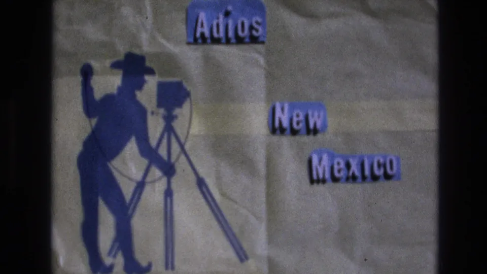 Final 1973 New Mexico title-card frame showing Adios New Mexico lettering, a blue cowboy silhouette, a camera on a tripod, and visible 8mm film texture.