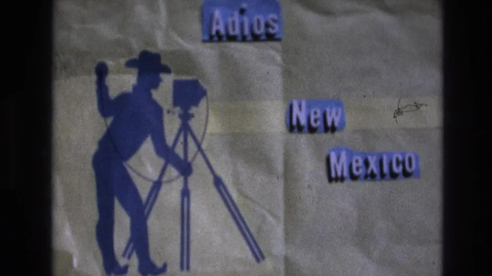 1973 New Mexico closing title card with blue lettering, a cowboy-like photographer silhouette, tripod camera, textured paper, and dark scan borders.