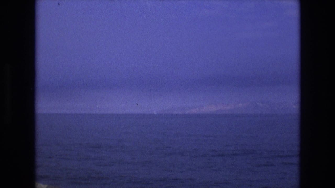 Dark blue water and low horizon under a twilight sky.