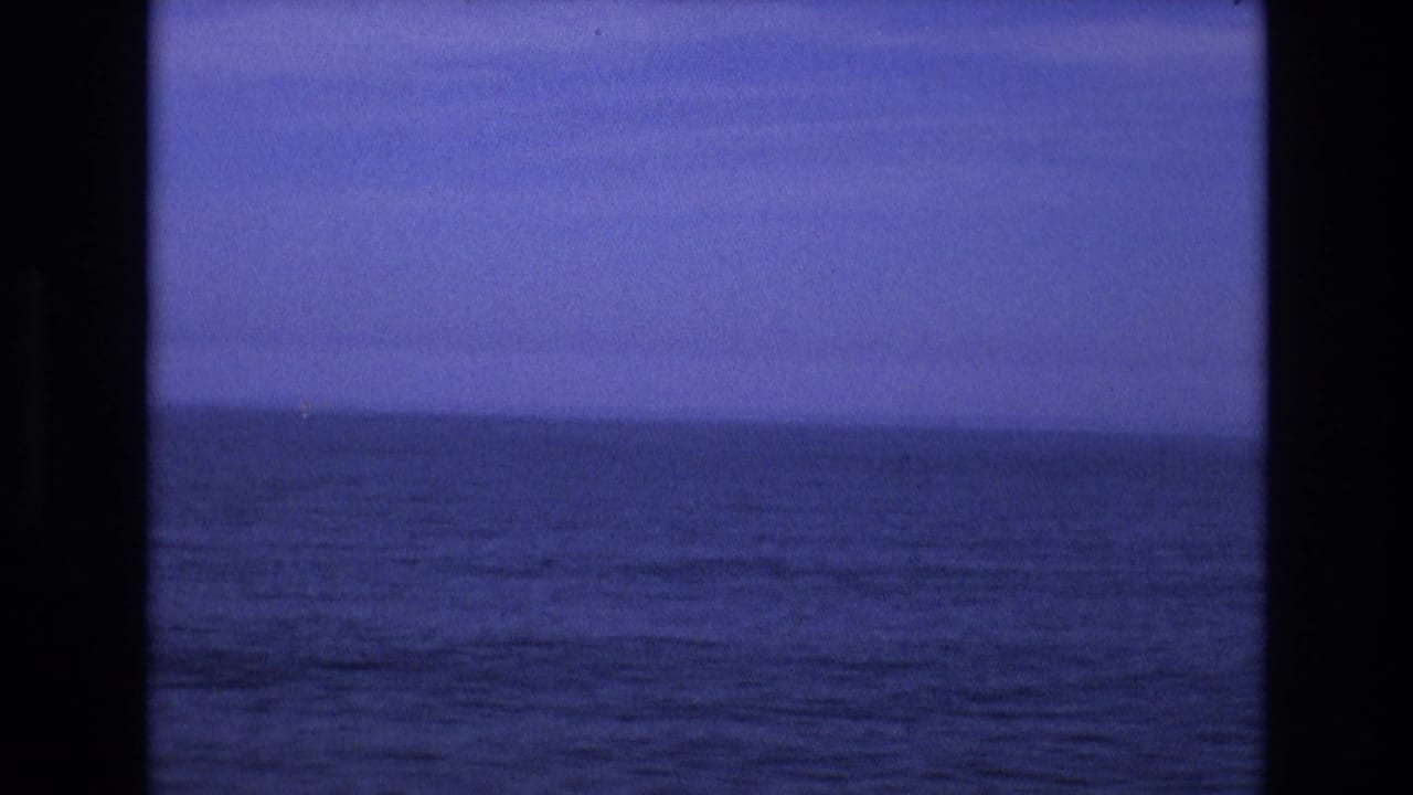 1973 8mm Salt Lake City-area home-movie frame showing open blue water and a distant horizon, with film gate edges visible.